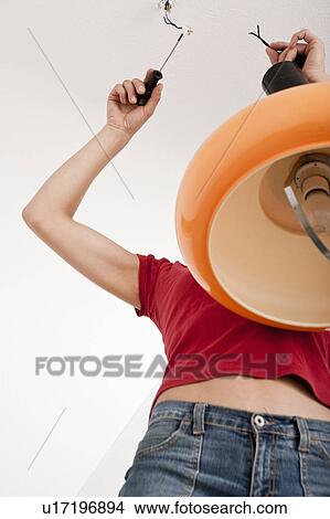 Woman fixing broken lamp View Large Photo Image Picture - Woman fixing broken lamp. Fotosearch