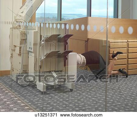 Stock Image - Woman fixing photocopier. Fotosearch