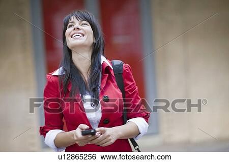 Stock Photograph - Woman getting a funny sms. Fotosearch