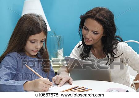woman helping girl work View Large Photo Image Stock Photography - woman helping girl work. Fotosearch