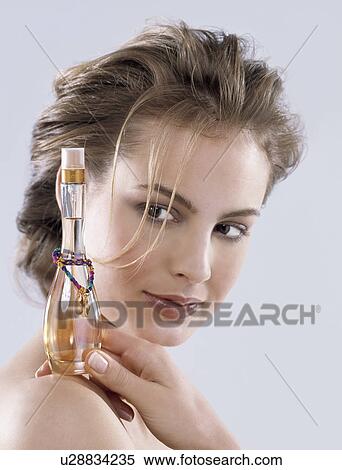 Stock Photography - Woman hold a bottle with Parfume. Fotosearch