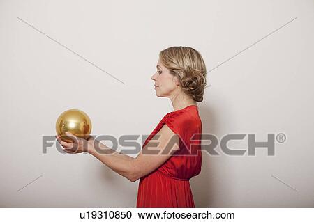 Woman holding a golden ball View Large Photo Image Stock Image - Woman holding a golden ball. Fotosearch