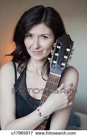 Stock Photo - Woman holding a guitar. Fotosearch