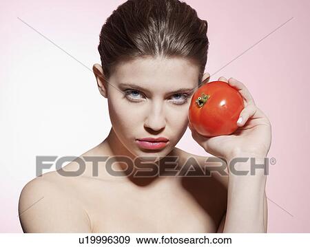 Woman holding a tomato View Large Photo Image Stock Photo - Woman holding a tomato. Fotosearch