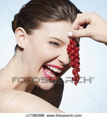 Stock Photograph - Woman holding bunch of cranberries. Fotosearch