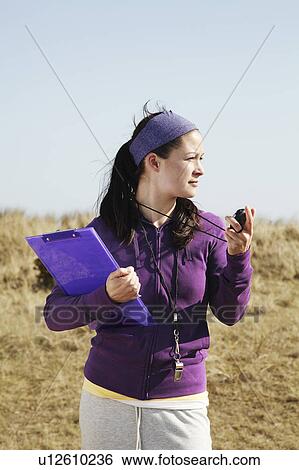 Woman holding clipboard and stopwatch View Large Photo Image Stock Photograph - Woman holding clipboard and stopwatch. Fotosearch