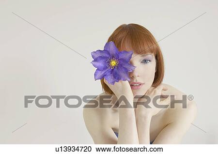 woman holding flower in front of eye View Large Photo Image Stock Image - woman holding flower in front of eye. Fotosearch