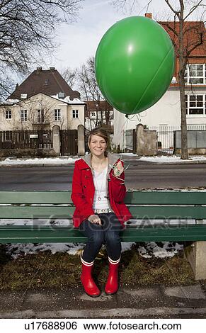 Stock Photograph - Woman holding green balloon. Fotosearch