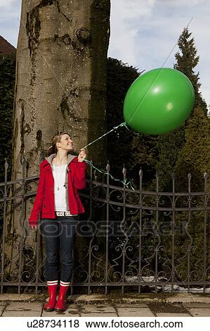 Woman holding green baloon View Large Photo Image Stock Photo - Woman holding green baloon. Fotosearch
