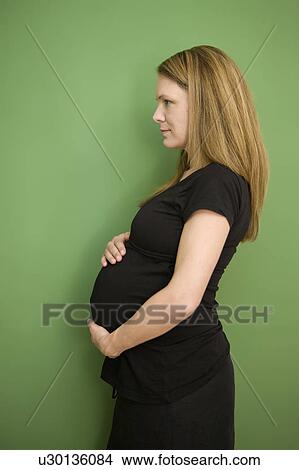 Picture - Woman holding pregnant belly. Fotosearch