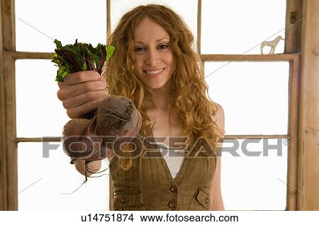 Woman holding vegetables in kitchen View Large Photo Image Picture - Woman holding vegetables in kitchen. Fotosearch