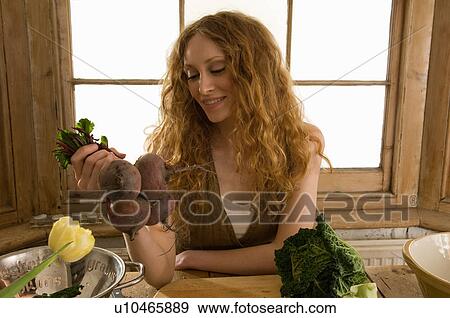 Woman holding vegetables in kitchen View Large Photo Image Stock Photo - Woman holding vegetables in kitchen. Fotosearch