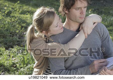 Woman hugging writing boyfriend View Large Photo Image Stock Photo - Woman hugging writing boyfriend. Fotosearch
