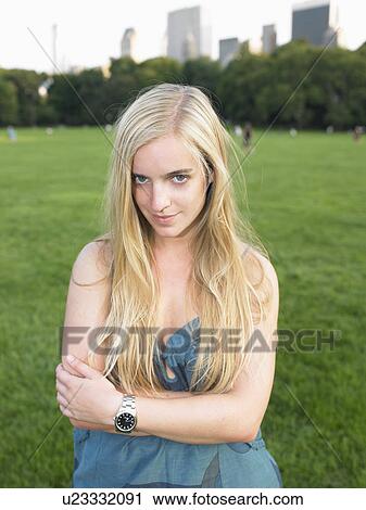 Stock Image - Woman in a park, looking at camera. Fotosearch