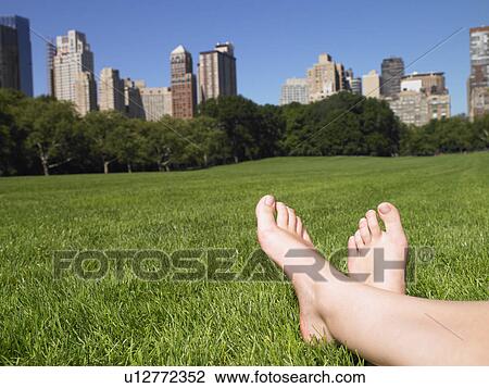 Stock Image - Woman in central park, enjoying the view. Fotosearch