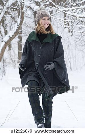Woman in heavy cape walking in snow View Large Photo Image Stock Photo - Woman in heavy cape walking in snow. Fotosearch