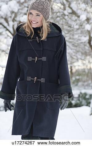 Woman in heavy coat walking in snow View Large Photo Image Stock Photo - Woman in heavy coat walking in snow. Fotosearch