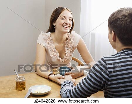 Woman laughing at boyfriend at table View Large Photo Image Stock Photo - Woman laughing at boyfriend at table. Fotosearch