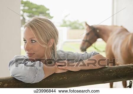 Woman leaning against stable gate View Large Photo Image Picture - Woman leaning against stable gate. Fotosearch