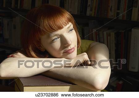 Stock Photograph - woman leaning on pile of books. Fotosearch