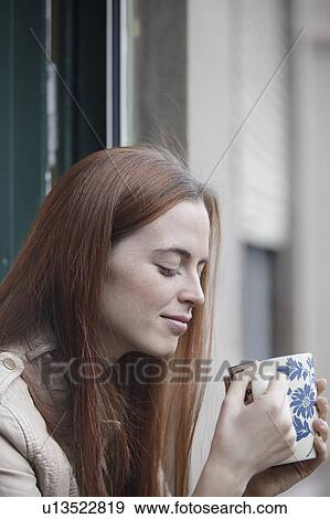 Woman leaning out of window holding cup View Large Photo Image Stock Photo - Woman leaning out of window holding cup. Fotosearch