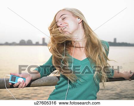 Woman listening to her mp3 player View Large Photo Image Stock Photograph - Woman listening to her mp3 player. Fotosearch