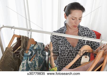 Stock Photography - woman looking at clothes. Fotosearch