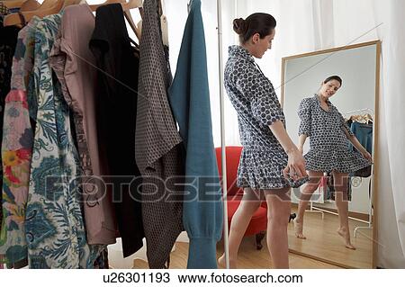 woman looking at dress in mirror View Large Photo Image Stock Image - woman looking at dress in mirror. Fotosearch