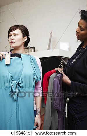 Woman looking at dresses View Large Photo Image Stock Image - Woman looking at dresses. Fotosearch