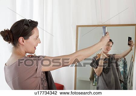 Stock Image - woman looking at phone. Fotosearch