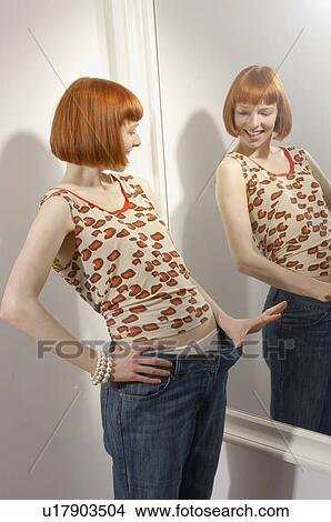 woman looking at weight loss in mirror View Large Photo Image Picture - woman looking at weight loss in mirror. Fotosearch