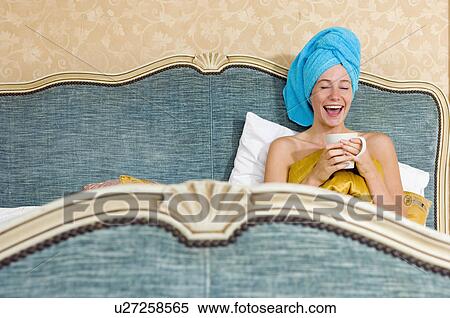 woman looking happy in bed with cup View Large Photo Image Stock Photography - woman looking happy in bed with cup. Fotosearch