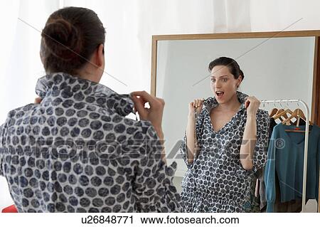 Stock Image - woman looking in mirror. Fotosearch