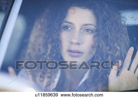 Woman looking out of a car window View Large Photo Image Stock Photo - Woman looking out of a car window. Fotosearch