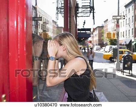 Woman looking through a shop window View Large Photo Image Stock Image - Woman looking through a shop window. Fotosearch