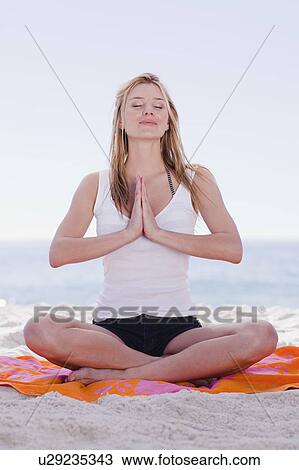 Woman meditating on towel at beach View Large Photo Image Stock Image - Woman meditating on towel at beach. Fotosearch