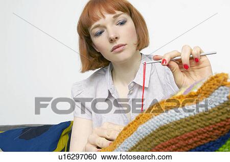 Stock Image - woman mending cushion. Fotosearch