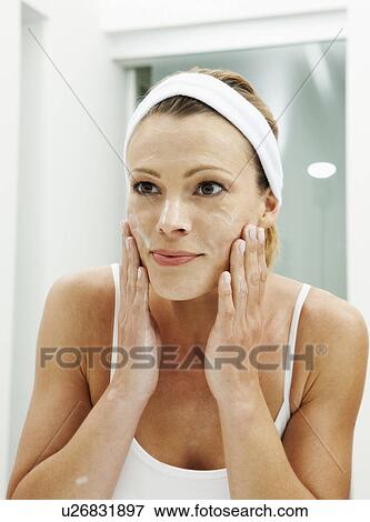 Woman moisturizing her face View Large Photo Image Stock Photo - Woman moisturizing her face. Fotosearch