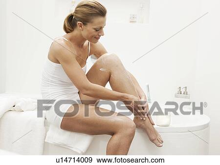 Woman moisturizing her legs View Large Photo Image Stock Photo - Woman moisturizing her legs. Fotosearch