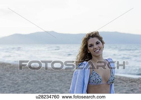 Stock Image - woman on beach smiling at camera. Fotosearch