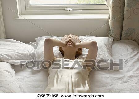 woman on bed with hands over eyes View Large Photo Image Stock Photograph - woman on bed with hands over eyes. Fotosearch