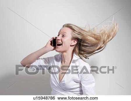 Woman on cellphoe hair flying View Large Photo Image Stock Photograph - Woman on cellphoe hair flying. Fotosearch