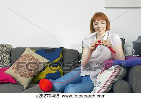 Stock Photo - woman on sofa knitting. Fotosearch