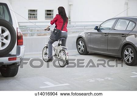 Woman parking a bicycle View Large Photo Image Picture - Woman parking a bicycle. Fotosearch