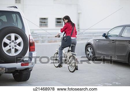 Stock Photo - Woman parking her bicycle. Fotosearch