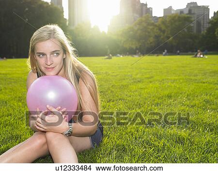 Woman playing with a balloon in a park View Large Photo Image Picture - Woman playing with a balloon in a park. Fotosearch