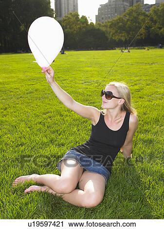 Woman playing with a balloon in a park View Large Photo Image Stock Image - Woman playing with a balloon in a park. Fotosearch