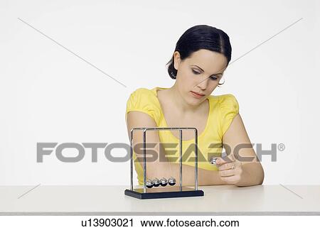 woman playing with newton's cradle View Large Photo Image Stock Image - woman playing with newton's cradle. Fotosearch