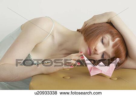 Stock Photo - woman playing with origami swan. Fotosearch