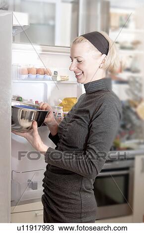 Woman pulling bowl from fridge View Large Photo Image Stock Image - Woman pulling bowl from fridge. Fotosearch